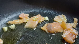 salmone affumicato rosolato in padella con olio e aglio